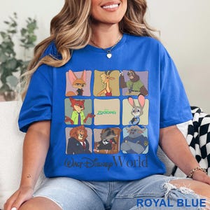 Puede incluir: Camiseta azul real con una cuadr&iacute;cula de personajes de Zootopia. La camiseta incluye el texto "Zootopia" y "Walt Disney World". La parte inferior de la camiseta tiene el texto "ROYAL BLUE".