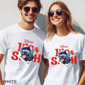 May include: White t-shirts featuring a Disney Lilo & Stitch design. The graphic shows Stitch popping out of a torn paper effect, with the Disney logo above. The text "Lilo & Stitch" is in red. The word "WHITE" is at the bottom.