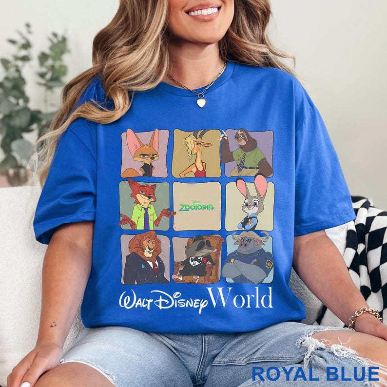 Puede incluir: Camiseta azul real con una cuadr&iacute;cula de personajes de Zootopia. La camiseta tiene el texto "Zootopia" y "Walt Disney World" impreso. La camiseta es de un estilo c&oacute;modo e informal.