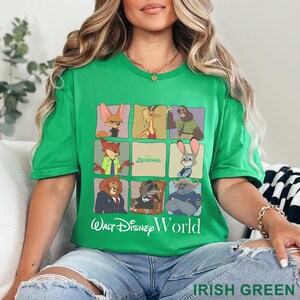 Puede incluir: Camiseta verde irland&eacute;s con una cuadr&iacute;cula de personajes de Zootopia. La camiseta incluye el texto "Zootopia" y "Walt Disney World" en blanco. La camiseta es de cuello redondo y manga corta.