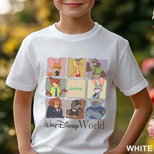 Puede incluir: Camiseta blanca con un gr&aacute;fico colorido de personajes de la pel&iacute;cula de Disney "Zootopia". El dise&ntilde;o incluye varios personajes de animales en marcos cuadrados, con el logotipo de "Zootopia" en el centro. Las palabras "Walt Disney World" est&aacute;n impresas debajo.