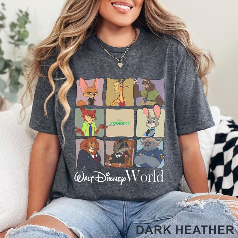 Puede incluir: Camiseta gris oscuro con un gr&aacute;fico colorido de personajes de la pel&iacute;cula de Disney Zootopia. La camiseta incluye el texto "Zootopia" y "Walt Disney World". La parte inferior de la camiseta tiene el texto "DARK HEATHER".