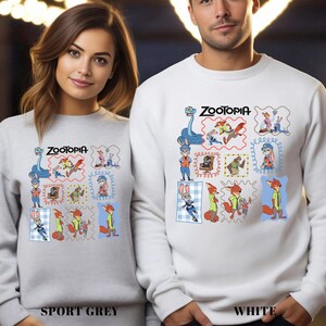 Puede incluir: Sudaderas deportivas grises y blancas con un dise&ntilde;o colorido de Zootopia. El dise&ntilde;o incluye varios personajes de la pel&iacute;cula en un estilo de sello postal. El texto "Zootopia" est&aacute; encima del dise&ntilde;o.