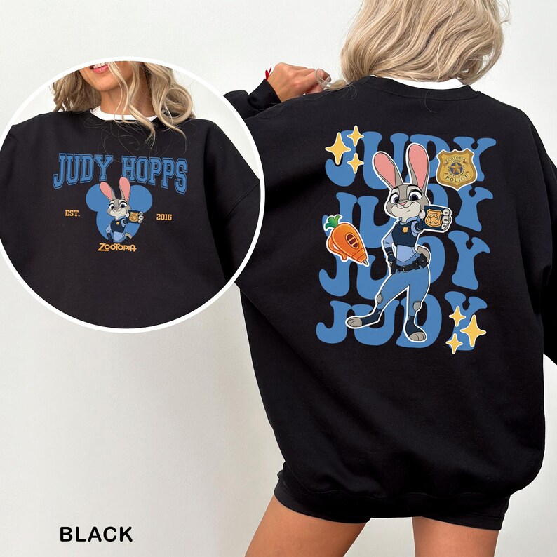 Puede incluir: Sudadera negra con Judy Hopps de Zootopia. El dise&ntilde;o frontal incluye el texto "JUDY HOPPS" y una imagen de dibujos animados de Judy. La parte trasera muestra un gr&aacute;fico m&aacute;s grande de Judy, texto y una zanahoria.
