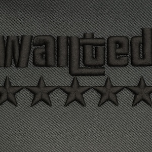 Pode incluir: Close-up de um tecido cinza escuro com a palavra "WANTED" bordada em preto, acima de uma fileira de cinco estrelas pretas. O texto e as estrelas são costurados com um efeito em relevo texturizado.