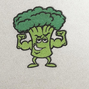 Può includere: Toppa ricamata raffigurante un personaggio di broccoli dei cartoni animati che flette le braccia. Il broccolo ha una testa e un corpo verdi, con un volto sorridente e braccia muscolose. La toppa è bordata di nero.
