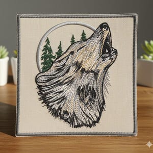 May include: Embroidered patch featuring a howling wolf with detailed fur in shades of gray, tan, and black. The wolf is set against a backdrop of a silver circle and green pine trees. The patch has a neutral-colored background and a gray border.