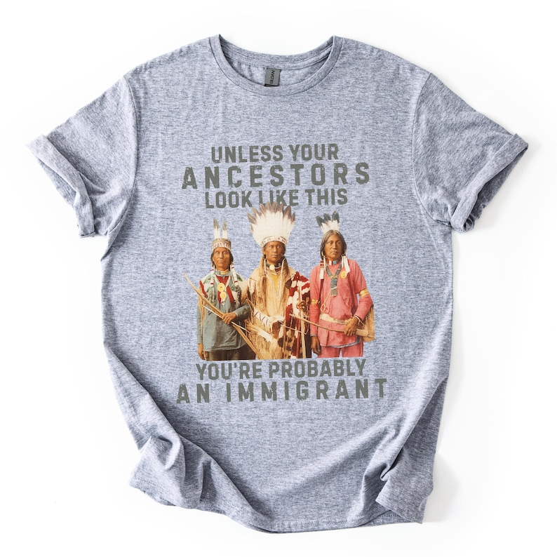 May include: A heather gray t-shirt with the text "UNLESS YOUR ANCESTORS LOOK LIKE THIS YOU'RE PROBABLY AN IMMIGRANT." The graphic features three Native American figures in traditional clothing.
