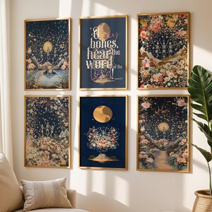 May include: Six framed art prints with gold frames are displayed on a white wall. The prints feature celestial and floral designs in shades of blue, pink, and gold. One print has the text "Dry bones, hear the word of the Lord!"
