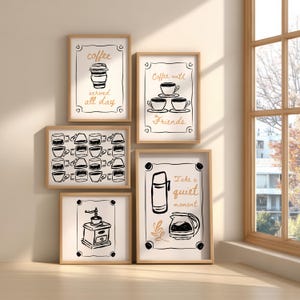 Może przedstawiać: Pięć oprawionych wydruków artystycznych z ilustracjami o tematyce kawowej. Wydruki przedstawiają rysunki filiżanek do kawy, młynka do kawy oraz tekst "coffee served all day", "Coffee with Friends" i "Take a quiet moment". Ramki są jasnobrązowe.
