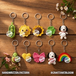 Puede incluir: Una colección de llaveros de ganchillo hechos a mano con varios diseños, incluyendo una vaina de guisantes, un girasol, un trébol de cuatro hojas, Snoopy, un aguacate, un corazón, un lazo y un arcoíris. Cada llavero tiene un anillo de metal y el texto "ORIGINAL". También se ven las palabras "HANDWRITTEN PATTERN" y "@CRAFTYARTBLOOM".