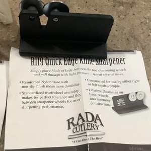 May include: Black R119 Quick Edge knife sharpener with two sharpening wheels. The sharpener has a reinforced nylon base and is designed for use by right or left-handed people. The product includes the text "RADA CUTLERY" and "A Cut Above The Rest."