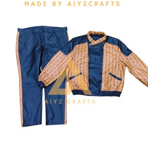 May include: A navy blue trouser and jacket set. The trousers have a peach-coloured stripe down the side. The jacket features a peach-coloured pattern on the sleeves and a navy blue front. The text "MADE BY AIYZCRAFTS" is at the top.