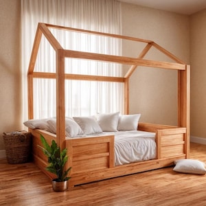 May include: A wooden house-shaped bed frame with a mattress and pillows. The bed is made of light-colored wood and has a simple, modern design. The room has hardwood floors, a woven basket, and a potted plant.