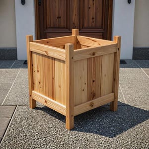 May include: A square wooden planter box with a natural wood finish. The planter has vertical wooden slats and corner posts. It is designed for outdoor use and sits on a stone patio.