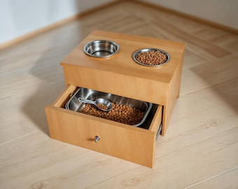 May include: A wooden pet food station with two stainless steel bowls and a drawer for storage. The bowls are filled with dry pet food.