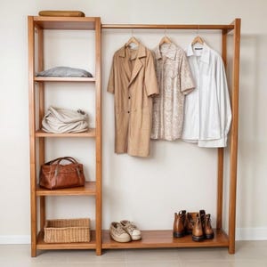 May include: A wooden clothes rack with shelves. The rack has a brown coat, two shirts, a brown bag, a wicker basket, and two pairs of brown shoes.