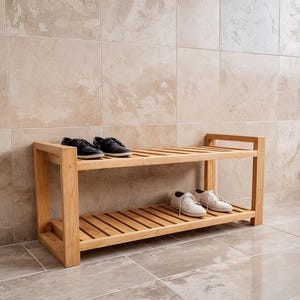 Peut inclure: Un présentoir à chaussures en bois brun clair à deux niveaux avec plusieurs paires de chaussures. Le présentoir a un design à lattes et est en bois naturel. Les chaussures sont des baskets noires et blanches.