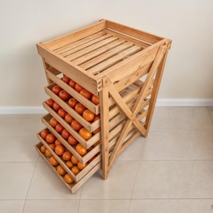 May include: A wooden fruit drying rack with multiple shelves filled with oranges. The rack is made of natural wood and has a rustic look.