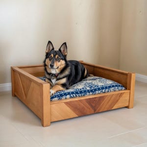 May include: A wooden dog bed with a blue and white patterned cushion. A black and brown dog is lying on the bed.