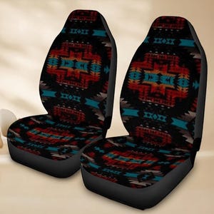 May include: Two car seat covers with a Southwestern design. The covers have a black background with a repeating pattern of red, turquoise, and gold geometric shapes. The seats have a black base and back.