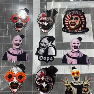 May include: A collection of nine vinyl stickers featuring Art the Clown from the Terrifier horror film series. The designs include various close-up portraits, full-body poses, and one sticker with the text "CLOWNS... AREN'T THEY FUCKING FUNNY?"