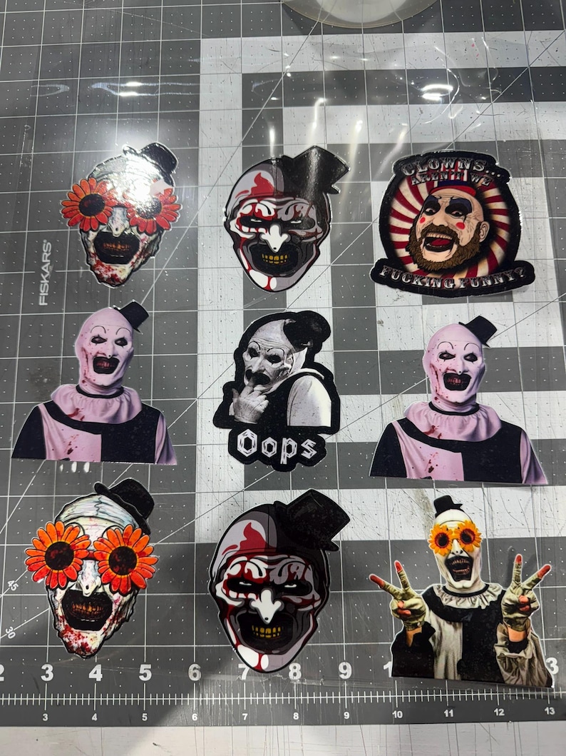 May include: A collection of nine vinyl stickers featuring Art the Clown from the Terrifier horror film series. The designs include various close-up portraits, full-body poses, and one sticker with the text "CLOWNS... AREN'T THEY FUCKING FUNNY?"