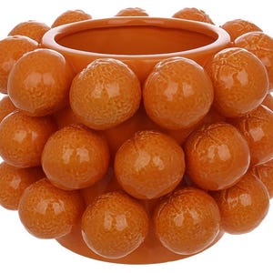 K&ouml;nnte beinhalten: Orangener Keramik-Pflanztopf mit einer strukturierten Oberfl&auml;che, die einem Cluster kleiner Orangen &auml;hnelt.