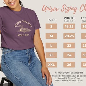 May include: A purple t-shirt with the text "STUPID CANADIAN WOLF BIRD" and a graphic of a loon. The image also includes a size chart with measurements in inches for width and length, and instructions for choosing the desired fit.