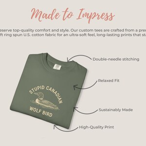 May include: Olive green t-shirt with the text "STUPID CANADIAN WOLF BIRD" and a graphic of a loon. The shirt has a relaxed fit and double-needle stitching. Made from soft ring spun U.S. cotton fabric.