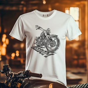 May include: White t-shirt featuring a detailed black and white motorcycle graphic with the word "FREEDOM" in a shadow effect. The shirt has a crew neck and short sleeves, perfect for casual wear.