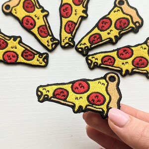 May include: Embroidered pizza slice patches with yellow crust, red pepperoni, and melted cheese details. These patches are perfect for adding a fun, food-themed touch to clothing, bags, or accessories. The patches are approximately 2 inches in length.