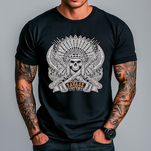 以下が含まれることがあります： 黒いTシャツ。詳細なグラフィックが特徴です。グラフィックは、羽飾りをかぶった頭蓋骨、交差した斧、そしてバナーに「SAVAGE」という言葉が描かれています。デザインはグレーと白のトーンです。