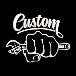 May include: A black graphic with the word "Custom" in white script above a clenched fist holding a wrench. The design has a 3D effect, with white outlines and shadows, creating a bold, eye-catching image.