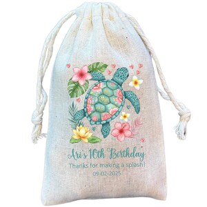 May include: A drawstring gift bag made of natural-colored fabric. The bag features a teal sea turtle design surrounded by pink and yellow flowers and green leaves. Text on the bag reads "Ari's 10th Birthday" and "Thanks for making a splash!"