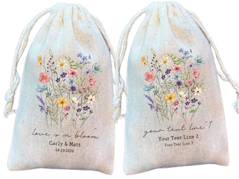 May include: Two beige drawstring favour bags featuring a watercolour floral design. Each bag has a bouquet of pink, blue, yellow, and purple flowers. One bag has the text "love is in bloom" with a name and date. The other has space for custom text.