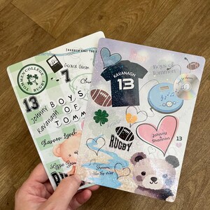 May include: Two decorative cards with rugby-themed designs. One card features a green and white design with text that says "Tommen College Rugby" and "Johnny Kavanagh 13". The other card has a blue and white design with a rugby ball and the text "Kavanagh 13".