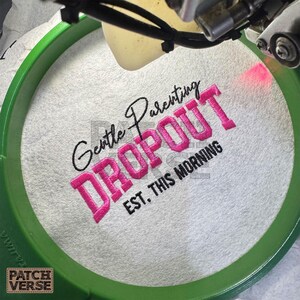 Gentle Parenting Dropout flat embroidery machine design featuring bold varsity lettering with script overlay stitched on a hat hoop setup. Funny mom life cap embroidery file perfect for dad hats, snapbacks and trucker hats. Digital embroidery design available in PES DST EXP VP3 HUS JEF XXX SEW formats for clean professional hat embroidery production..