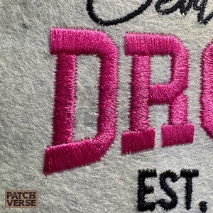 Gentle Parenting Dropout flat embroidery machine design featuring bold varsity lettering with script overlay stitched on a hat hoop setup. Funny mom life cap embroidery file perfect for dad hats, snapbacks and trucker hats. Digital embroidery design available in PES DST EXP VP3 HUS JEF XXX SEW formats for clean professional hat embroidery production..