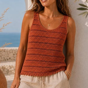 May include: A rust-coloured sleeveless crochet tank top featuring a repeating horizontal openwork pattern and a scoop neckline, paired with light beige linen shorts that have a drawstring waist and a cuffed hemline.