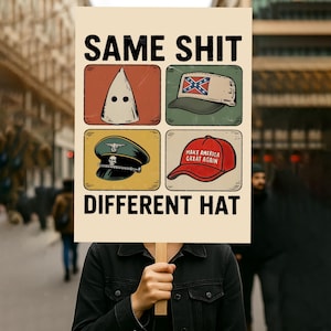 May include: A sign with the text "SAME SHIT DIFFERENT HAT" and illustrations of a KKK hood, a Confederate flag hat, a Nazi cap, and a "Make America Great Again" hat. The sign is held by a person.
