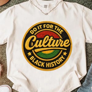 Puede incluir: Camiseta blanca con un gráfico circular que dice "Do It For The Culture" y "Black History". El gráfico presenta colores rojo, amarillo, verde y negro. La camiseta tiene cuello redondo y mangas cortas.