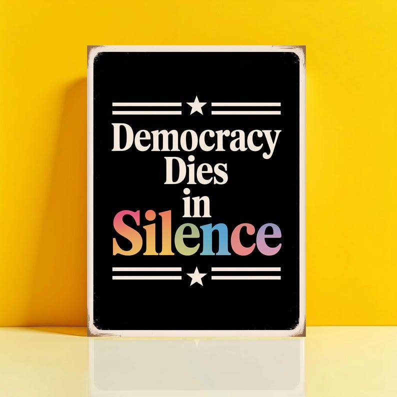 Może przedstawiać: Czarny znak z białym tekstem, kt&oacute;ry brzmi "Democracy Dies in Silence" ze słowem "Silence" w kolorze tęczy.