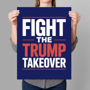 May include: A navy blue poster with the words "FIGHT THE TRUMP TAKEOVER" in white and red lettering. The poster is held by a person wearing a black and white checkered shirt.