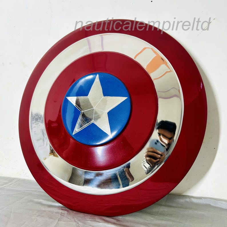 May include: A red, white and blue Captain America shield with a silver metal rim. The shield has a large, five-pointed star in the centre.