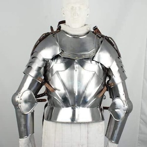 May include: A silver plated suit of armour with a breastplate and pauldrons. The armour is made of metal and has a polished finish.