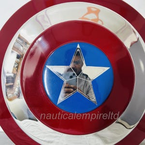 May include: A red, white and blue Captain America shield with a silver metal rim. The shield has a large, five-pointed star in the centre.