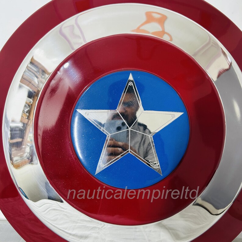 May include: A red, white and blue Captain America shield with a silver metal rim. The shield has a large, five-pointed star in the centre.