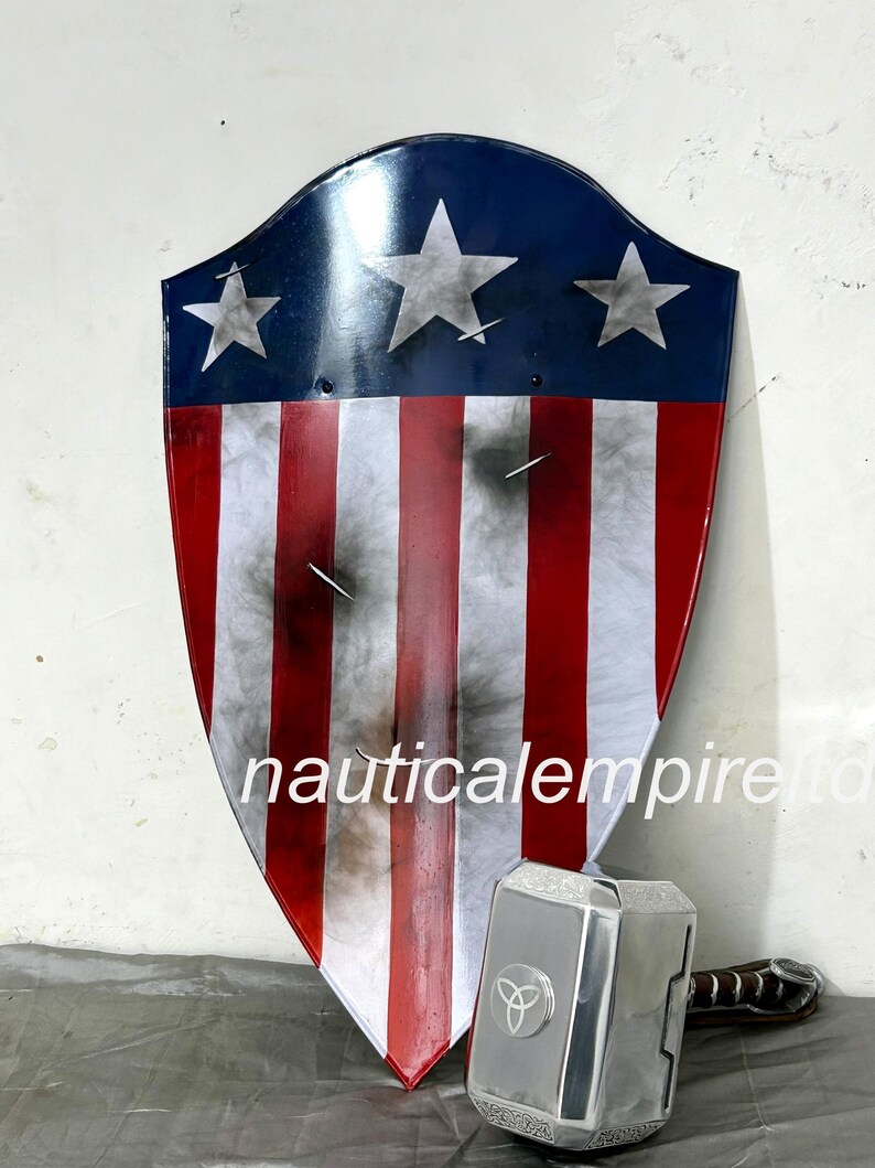 May include: A red, white, and blue shield with a star design, similar to the American flag, with a silver metal hammer with a black handle and a three-pointed star design on the head.