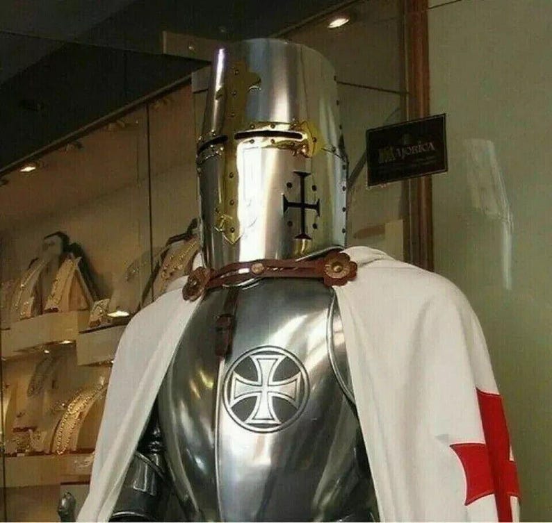 May include: A silver knight's armor with a white cape and a red cross. The knight is wearing a helmet with a gold cross on the front.